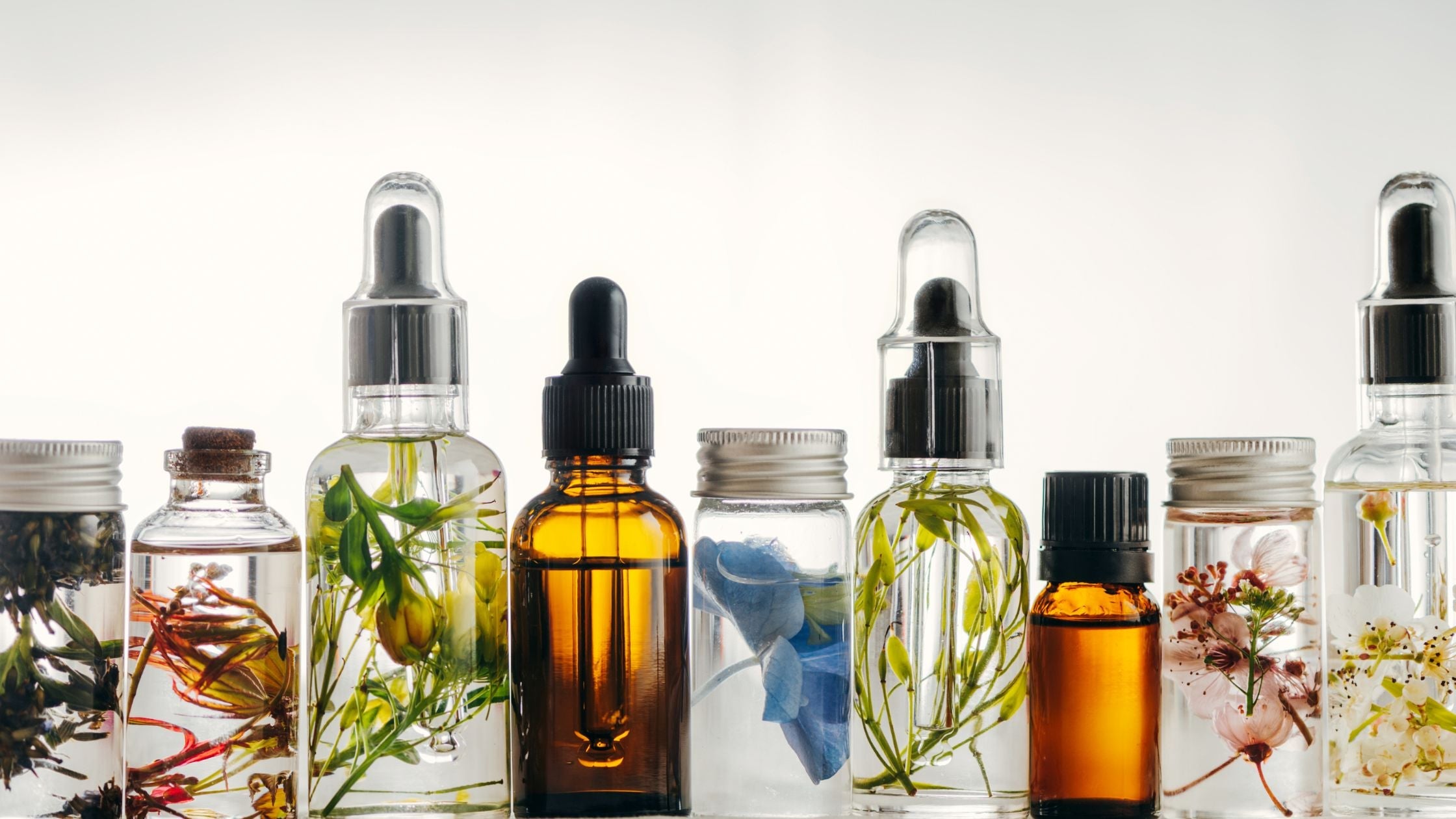 Glass dropper bottles filled with natural essential oils and botanical extracts, ideal for sun-damaged skin, actinic keratosis, and daily skincare routines.